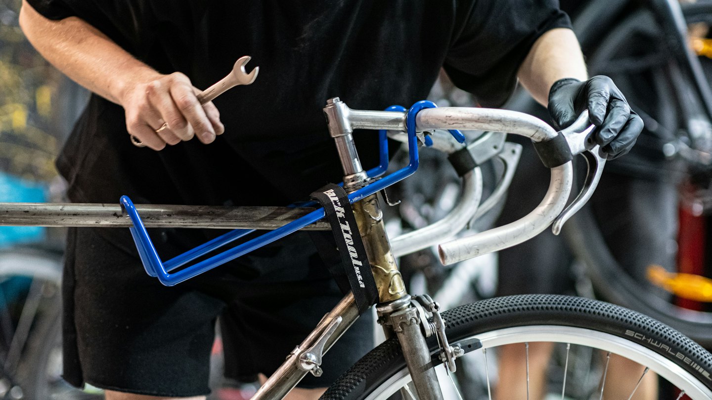 Mechanik rowerowy pracuje przy kierownicy roweru z kluczem.